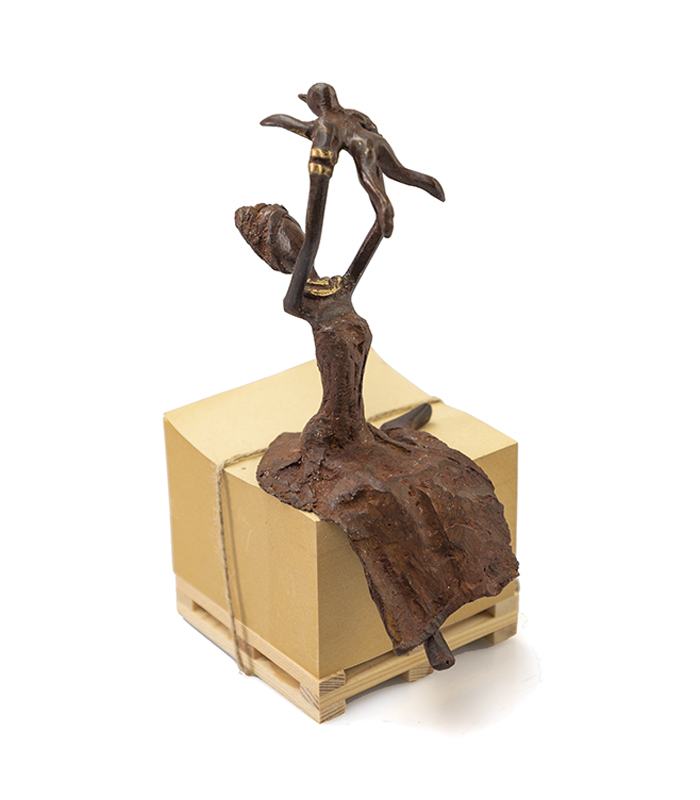 Afrikansk rød kvinde holder baby op. Fairtrade figur